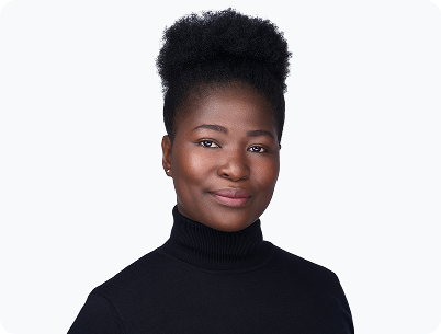 A professional headshot of a Black woman with a slight, confident smile. She has her hair styled in a high bun with shaved sides. She is wearing a black turtleneck and is photographed from the chest up against a pure white background.